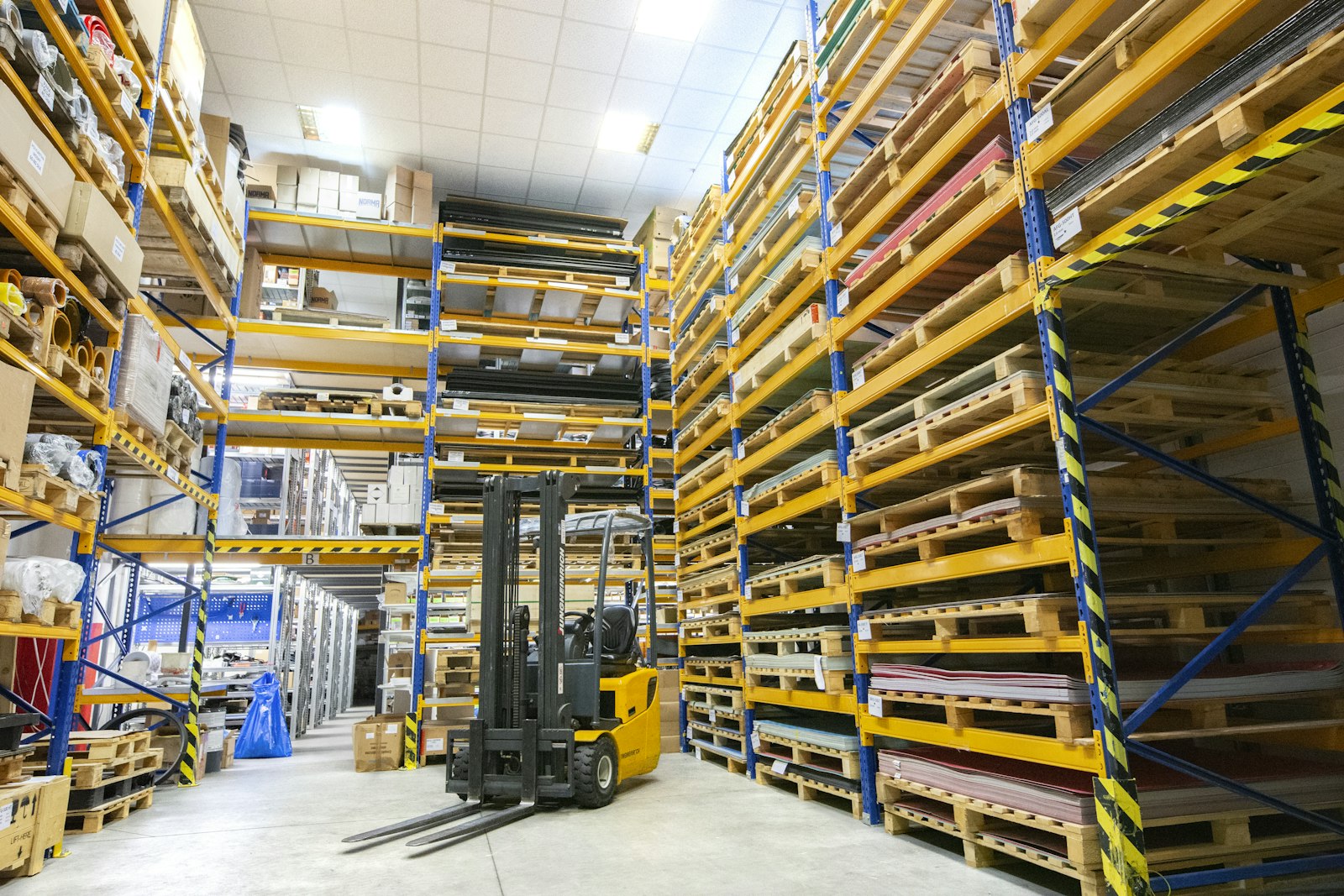 Depósito con pallets apilados y un montacargas