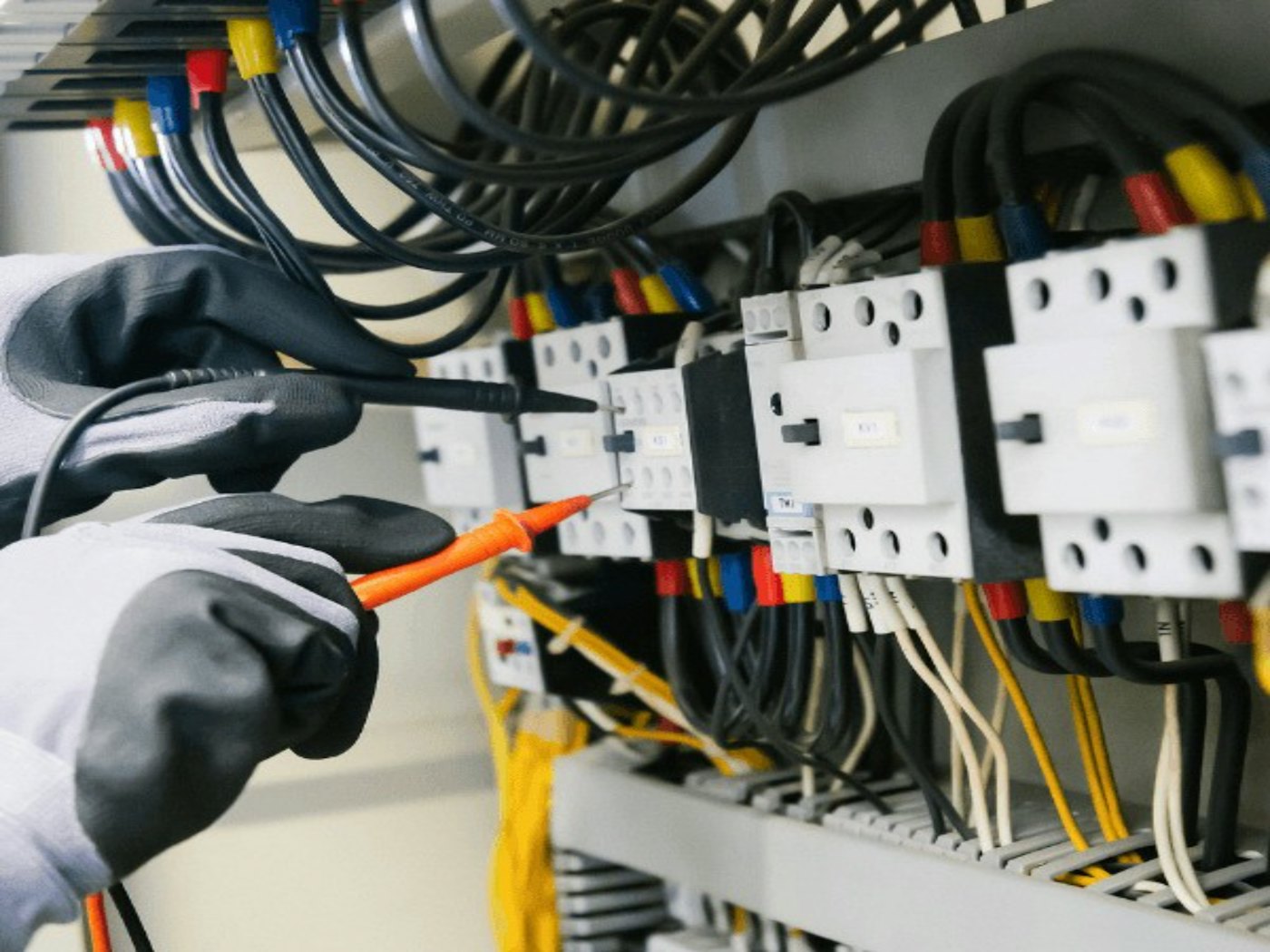 Electricista probando un tablero eléctrico con un multímetro